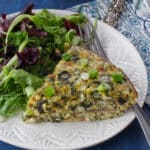 slice of ww quiche on a plate with mixed greens