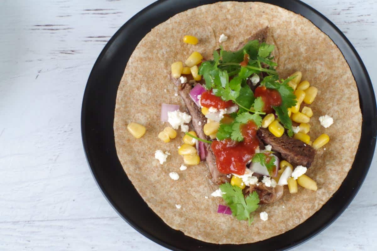 Beef and toppings added to tortillas