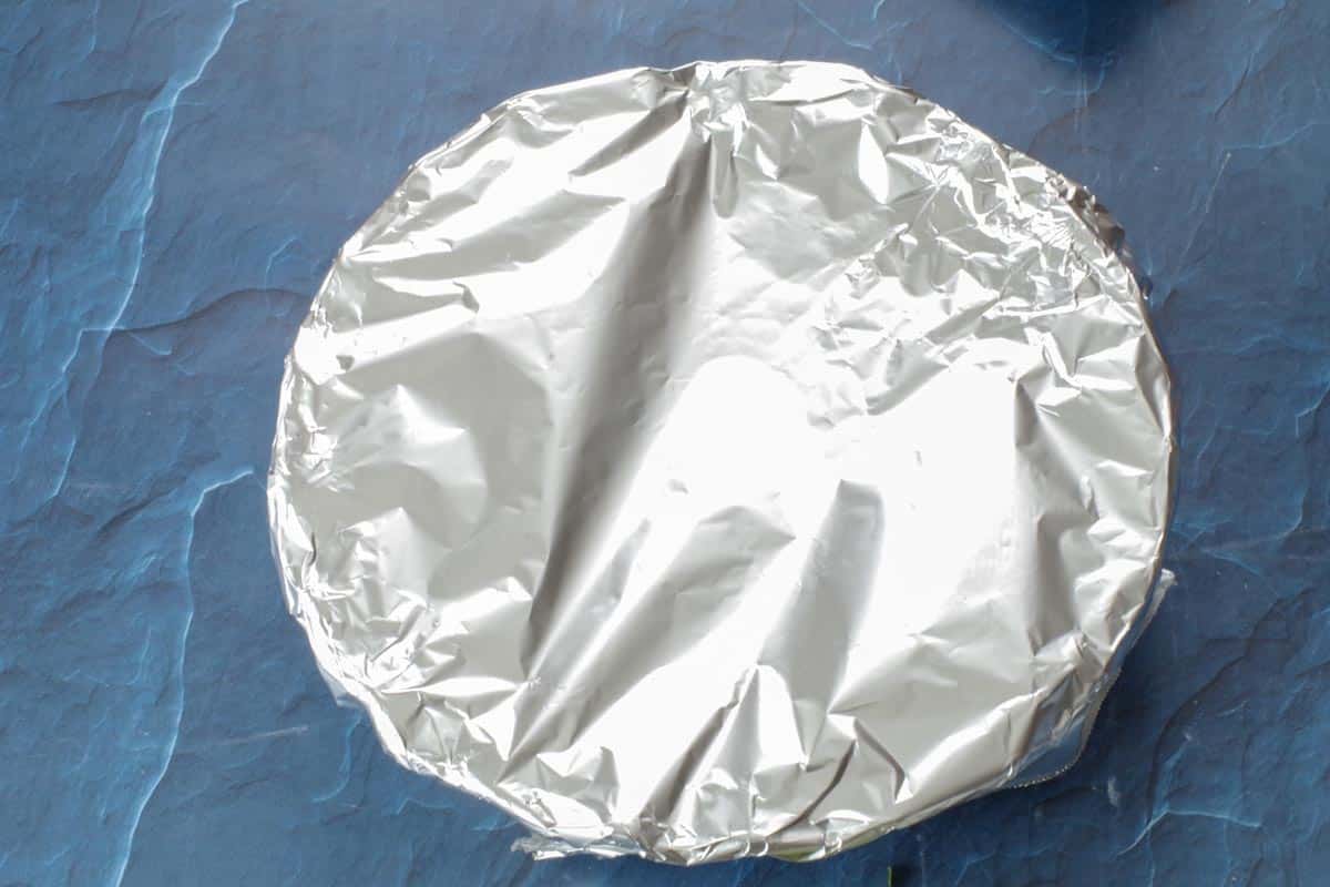 quiche in pie dish with foil over top (sealed)