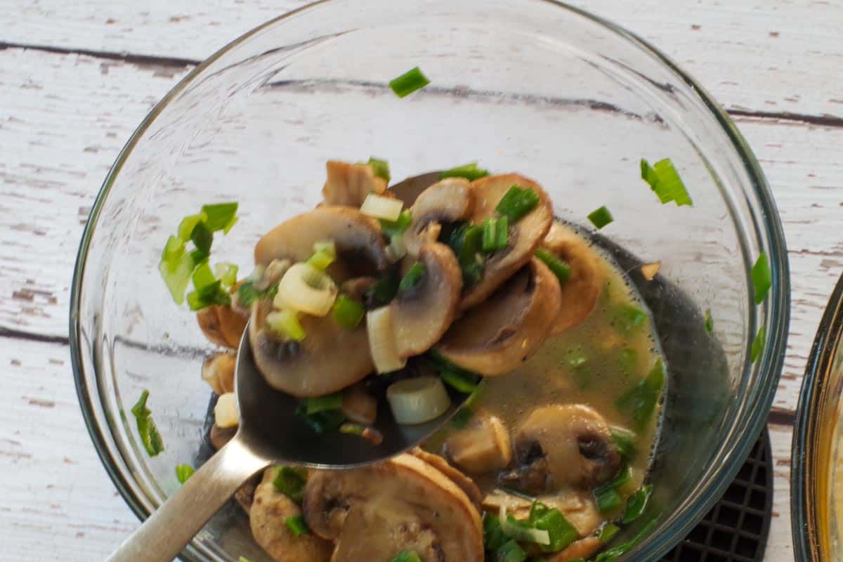 slotted spoon with mushroom and onion being strained