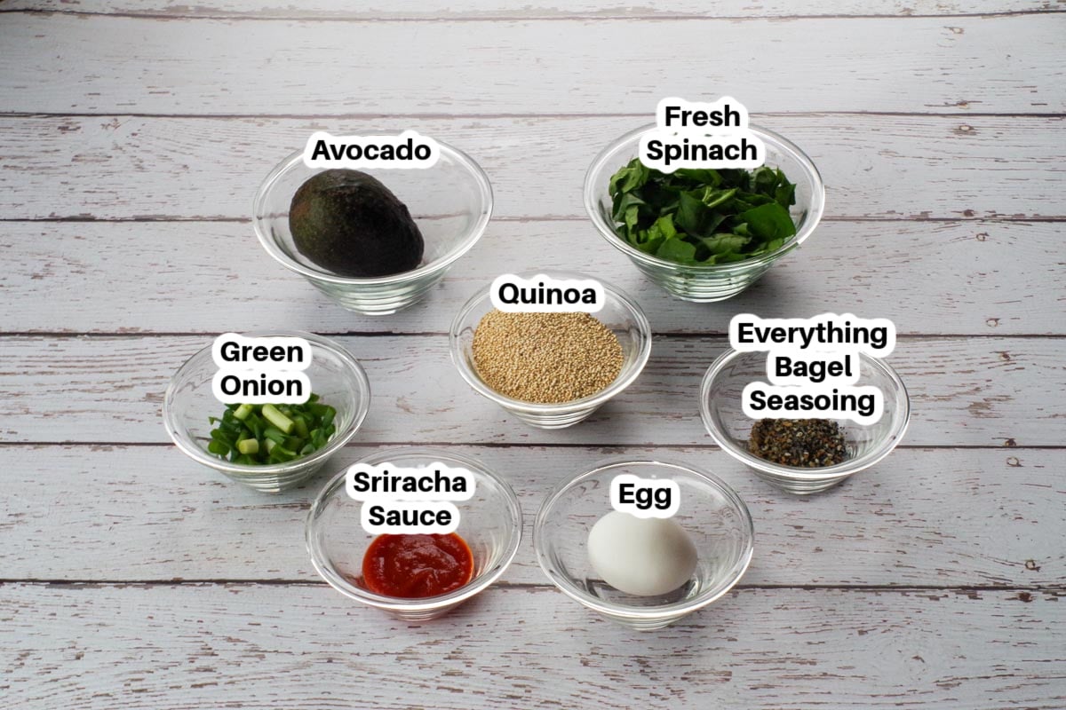 Ingredients in Avocado Breakfast Bowl in glass bowls on a faux wood surface, labelled
