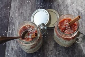 2 jars of rhubarb overnight oats with rhubarb puree added. as well as cinnamon and coconut garnish