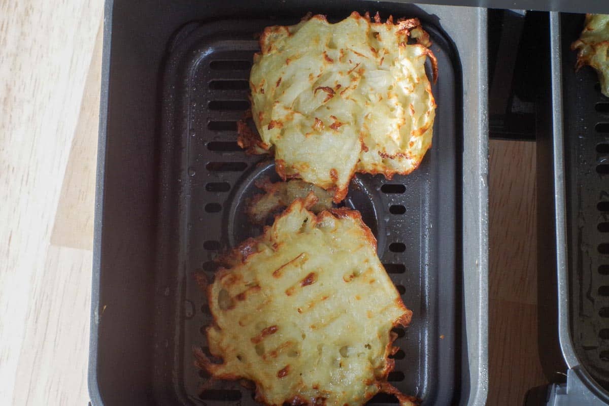 Air fryer potato pancakes cooked on both sides in air fryer drawer