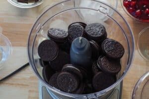 melted butter and Oreos in bowl of food processor