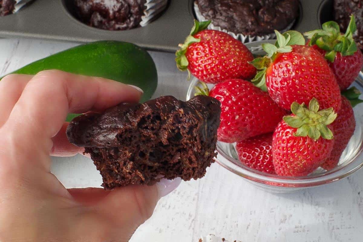 weight watchers chocolate zucchini muffin, with a bite out of it, being held