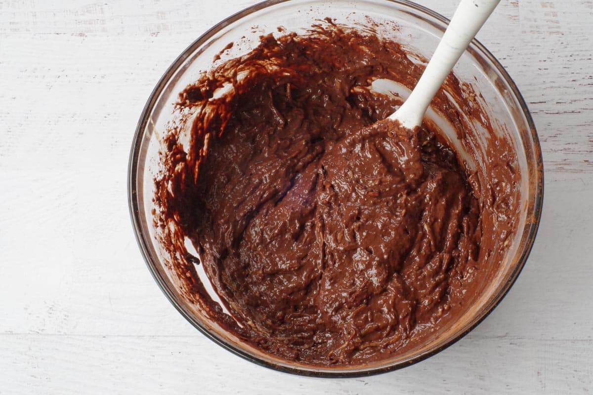 dry ingredients and wet ingredients mixed into a glass bowl