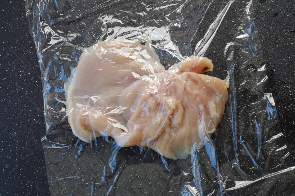 chicken breast under saran wrap