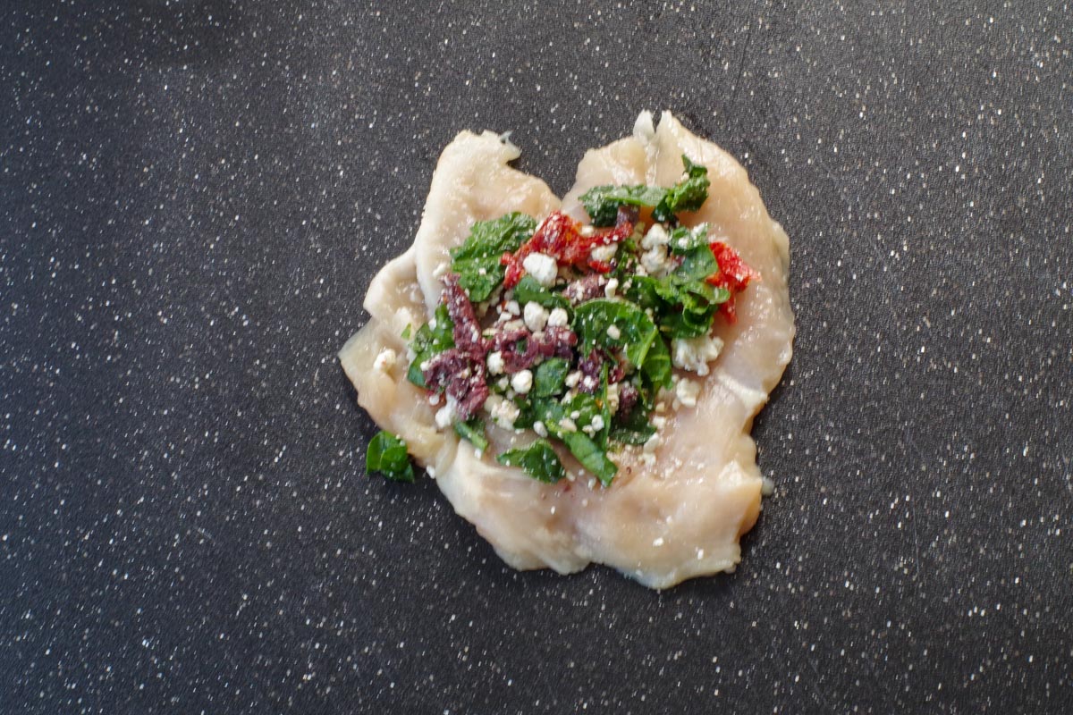 filling put on chicken breast on cutting board