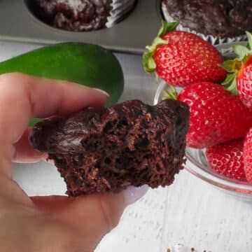 weight watchers chocolate zucchini muffin, with a bite out of it, being held