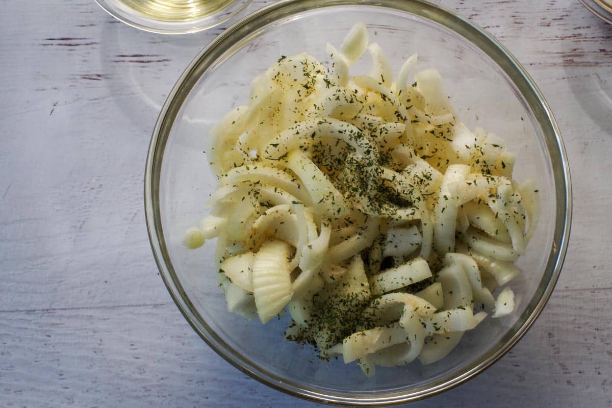 onion sprinkled with half the parsley and garlic powder in a glass bowl