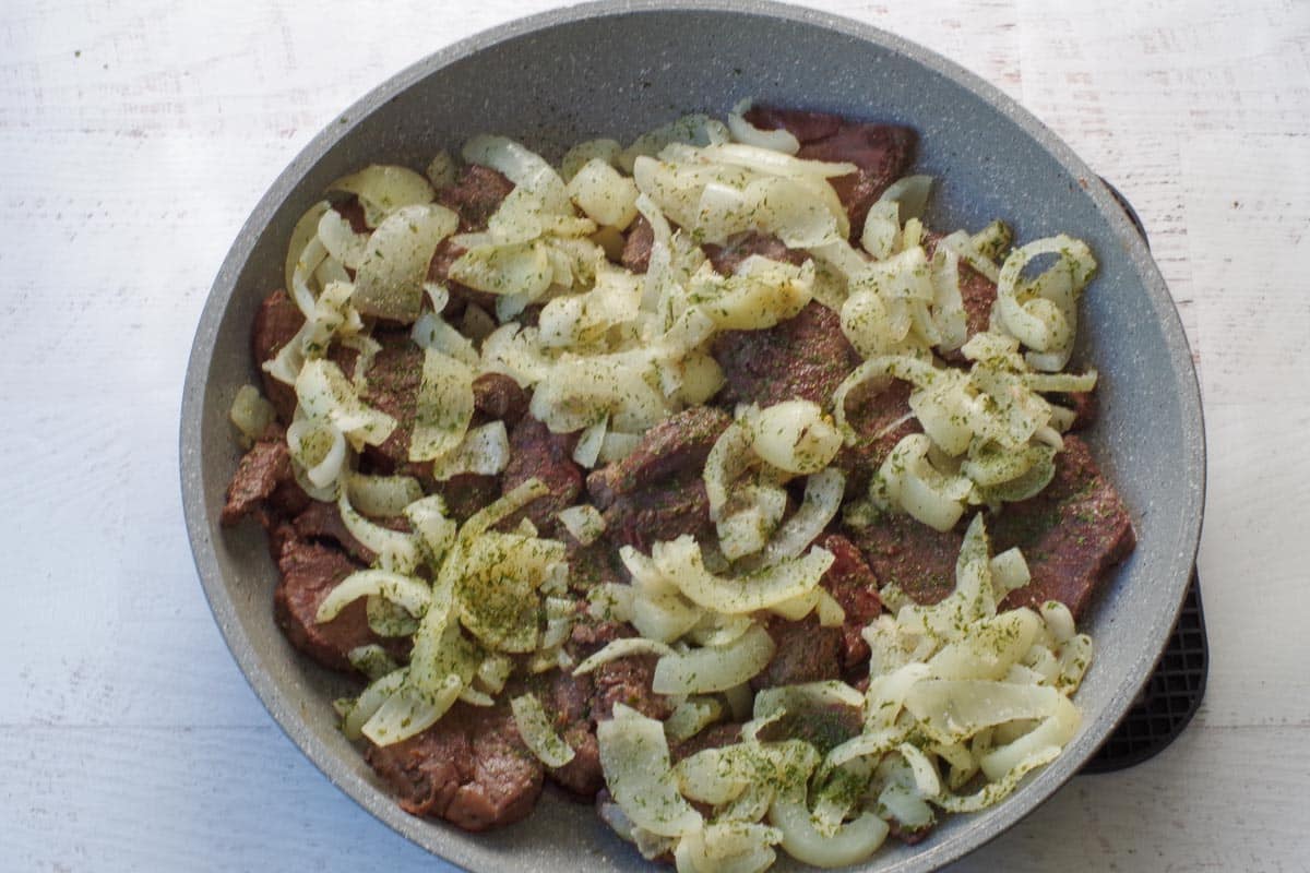 onions added to skillet with venison