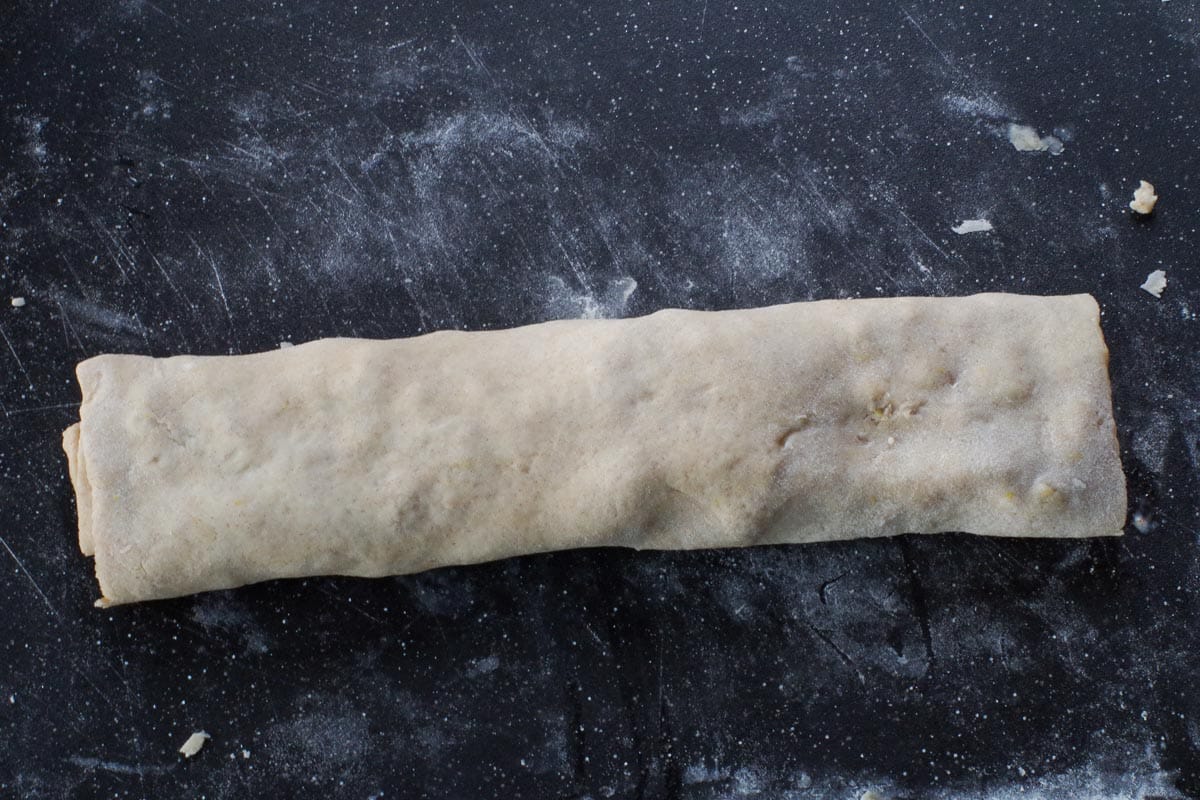 apple rolled up in scone dough on cutting board