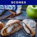 apple cinnamon scones on a black serving platter with a green apple and blue paisley patterned oven mitts in the background