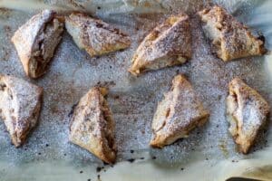 baked scones on parchment paper, sprinkled with powdered sugar