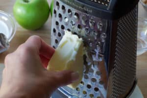 frozen butter being grated on a cheese grater