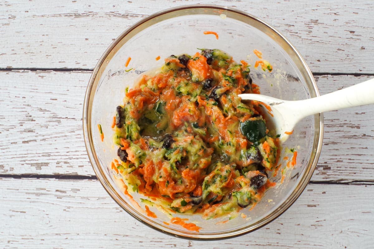 wet ingredients mixed together in a glass bowl with a marble silicone spoon