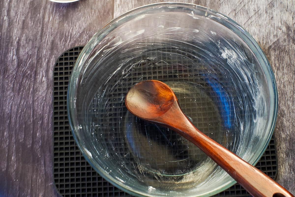 glass bowl and wooden spoon greased with shortening