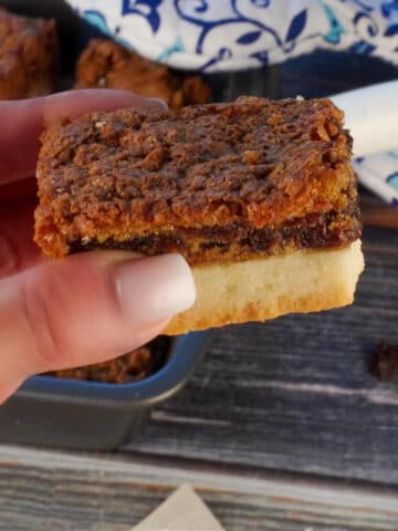 Butter tart square being held up in a hand