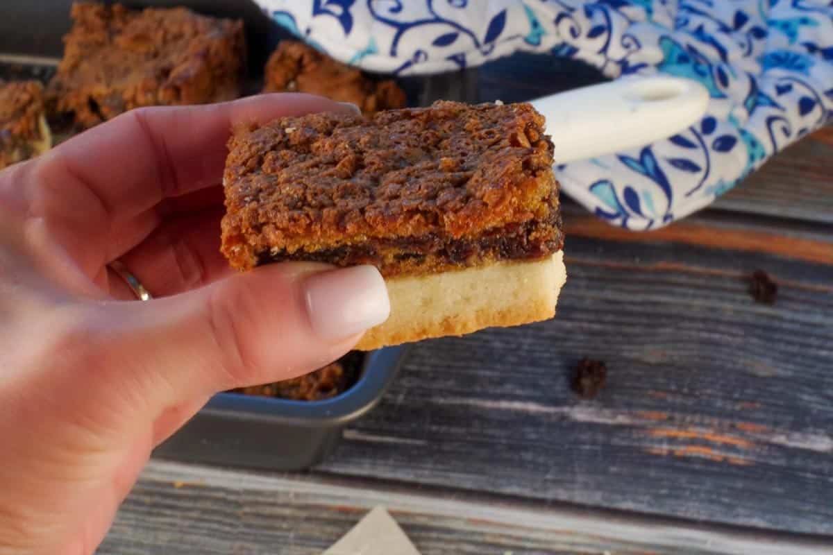 Butter tart square being held up in a hand