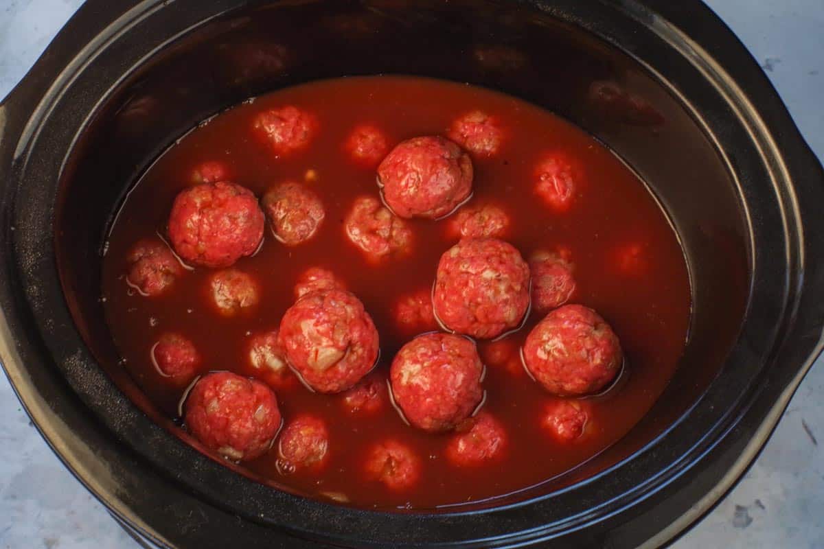 Sauce poured over meatballs in slow cooker.