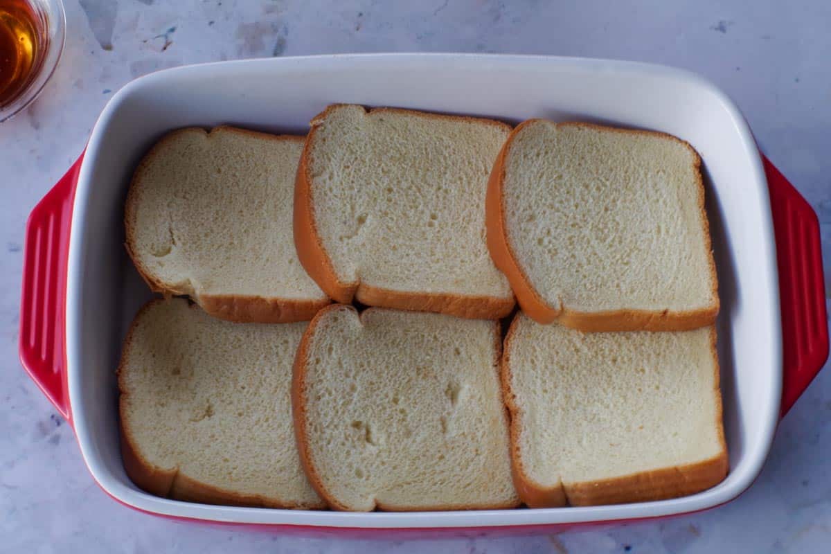 1st layer of bread added to the casserole dish