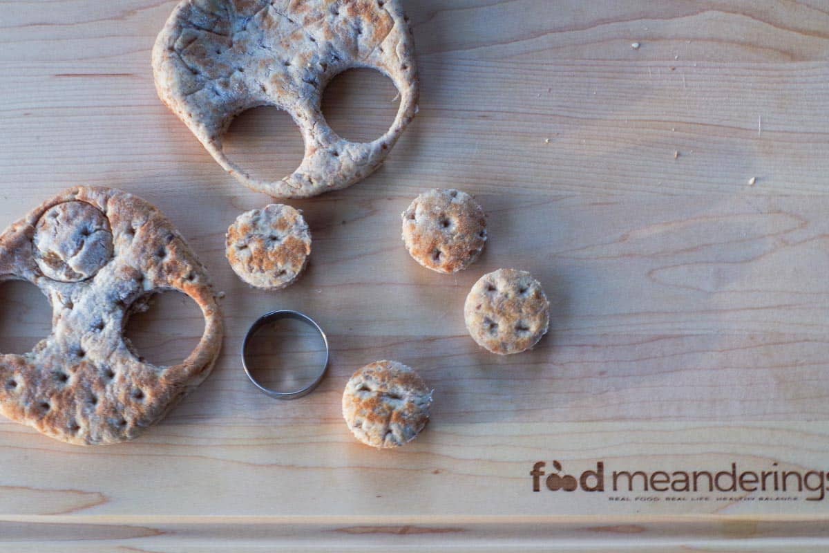 Mini buns cut out of thin buns with mini round cookie cutter on cutting board.