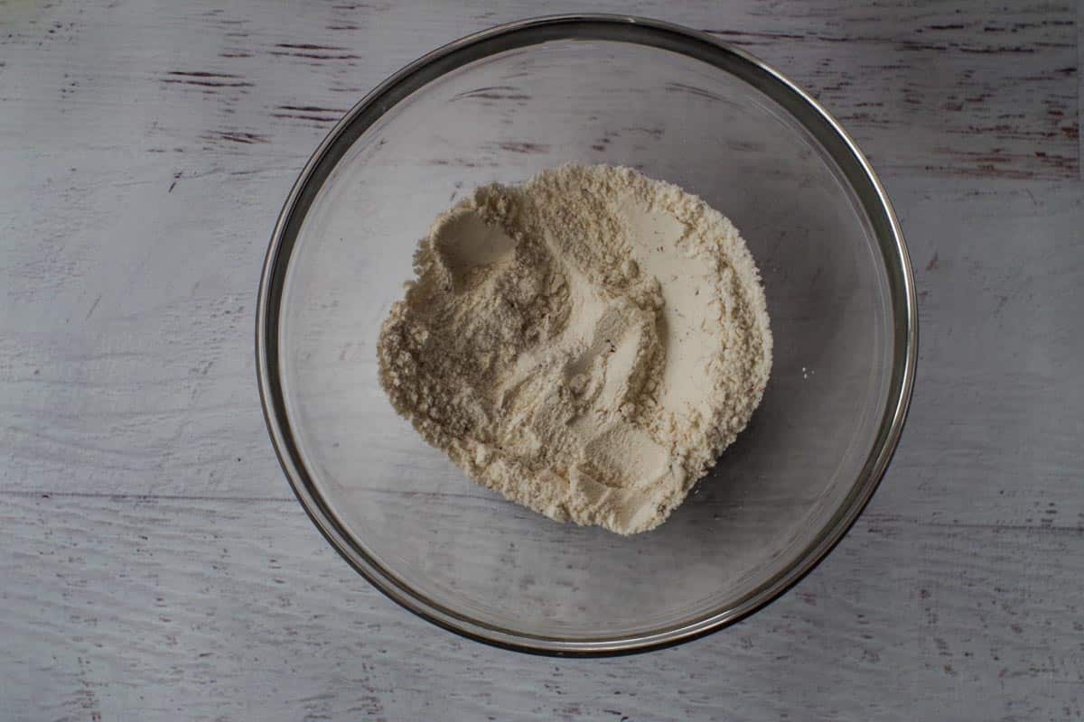 Salt, pepper and flour mixed together in glass bowl.