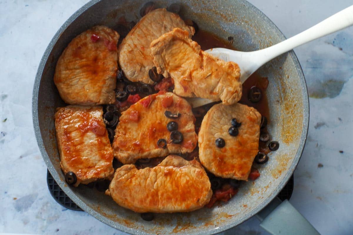 Pork and salsa, black olives, water and rosemary simmered in frying pan.