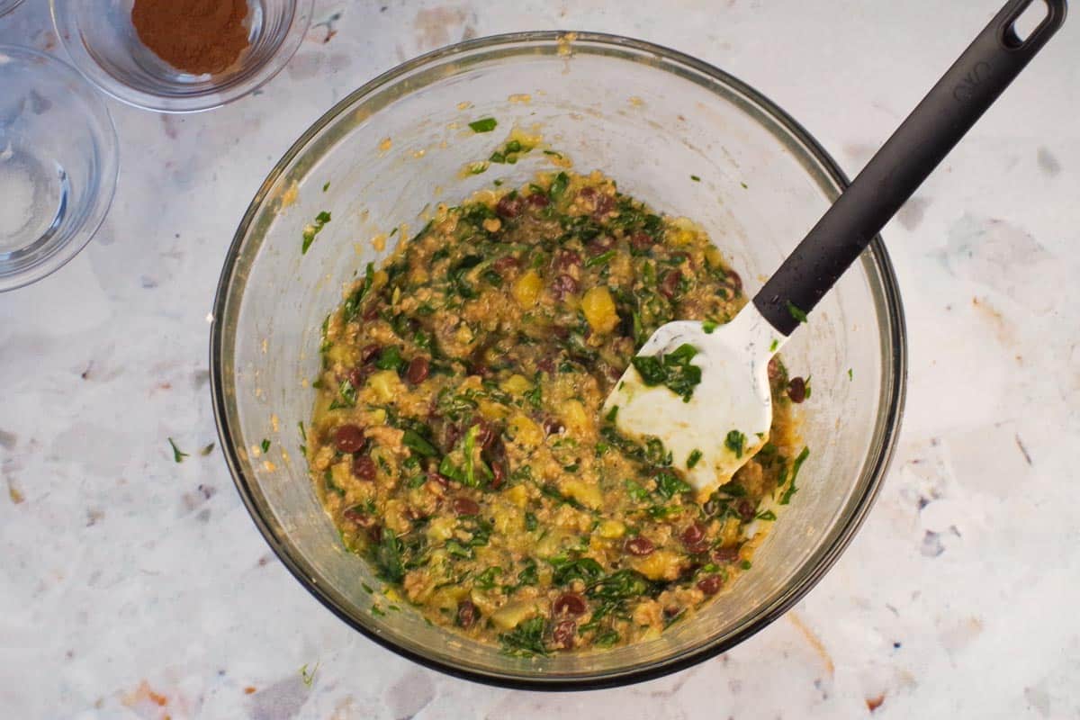 Wet ingredient mixed together in large glass bowl with spatula.