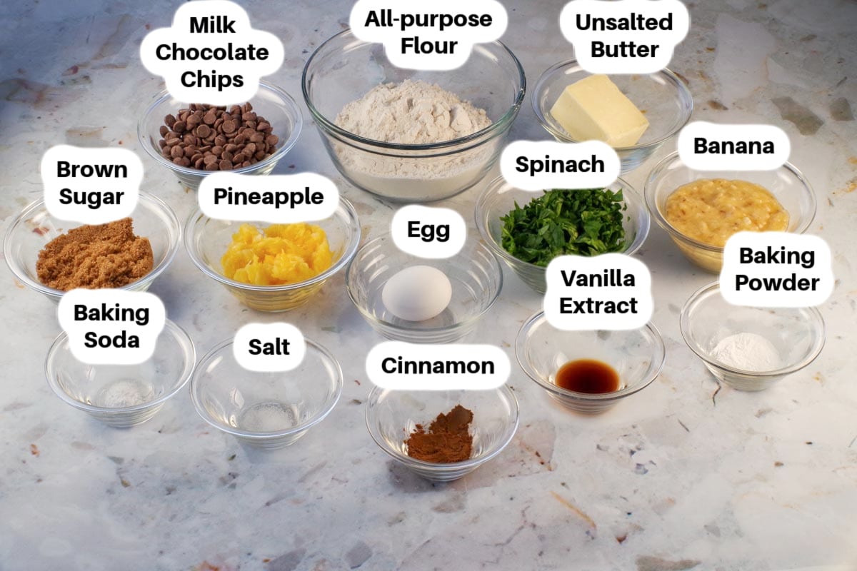 Ingredients in healthy chocolate chip spinach cookies in glass bowls, labelled.