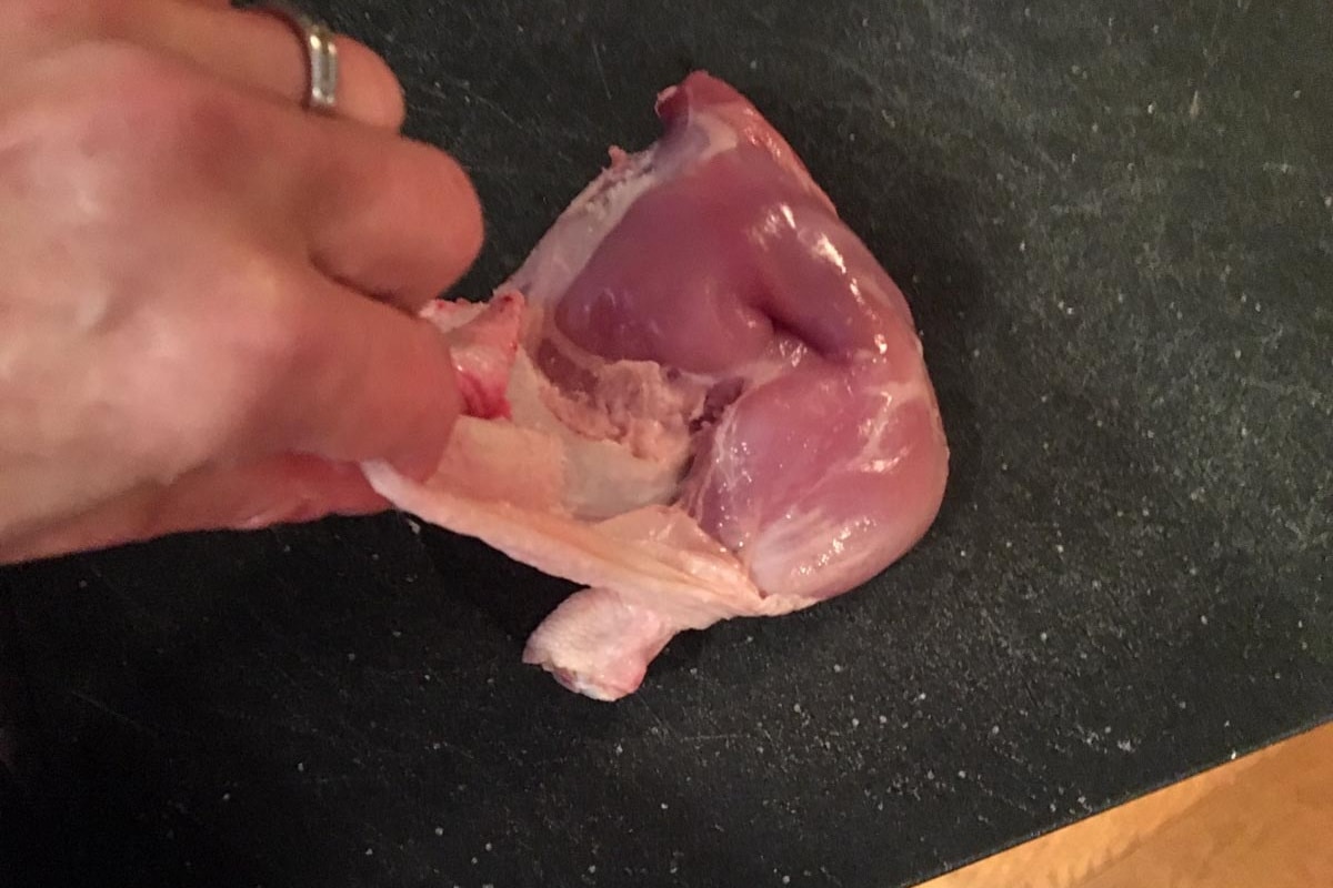 Skin being pulled off chicken,