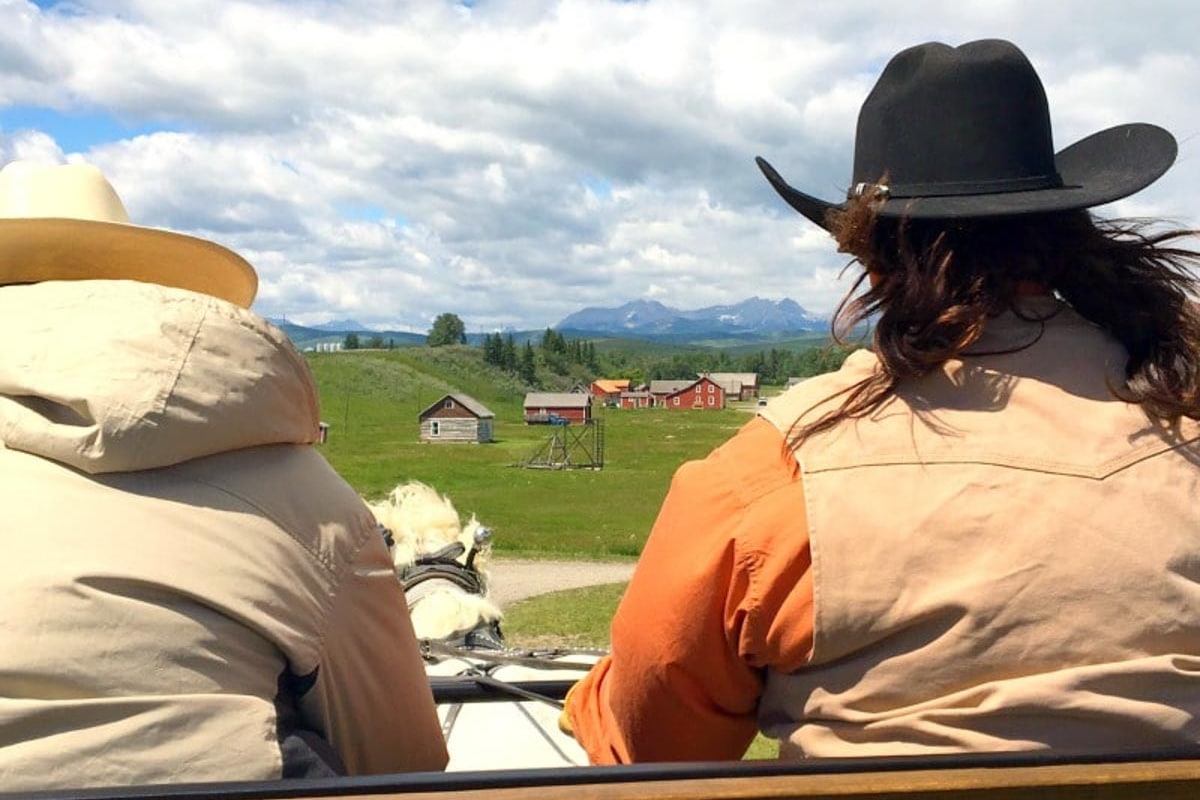 View of mountains and Bar U Ranch from the back of a horse-drawn wagon,