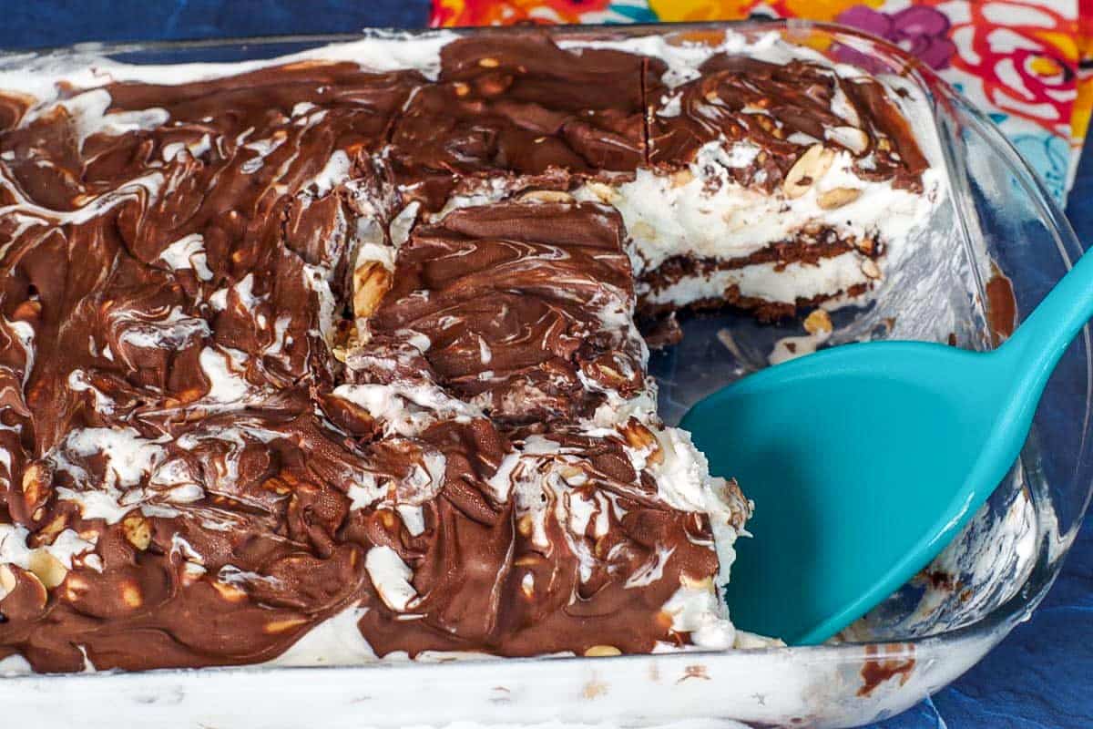 buster bar cake with piece missing, with turquoise spatula in pan