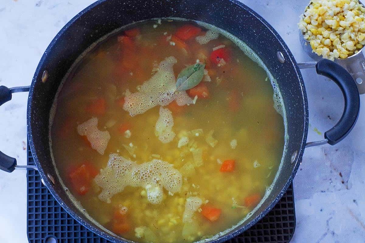 Potatoes, thyme, bay leaf, salt, pepper, and some of the corn added to the pot.