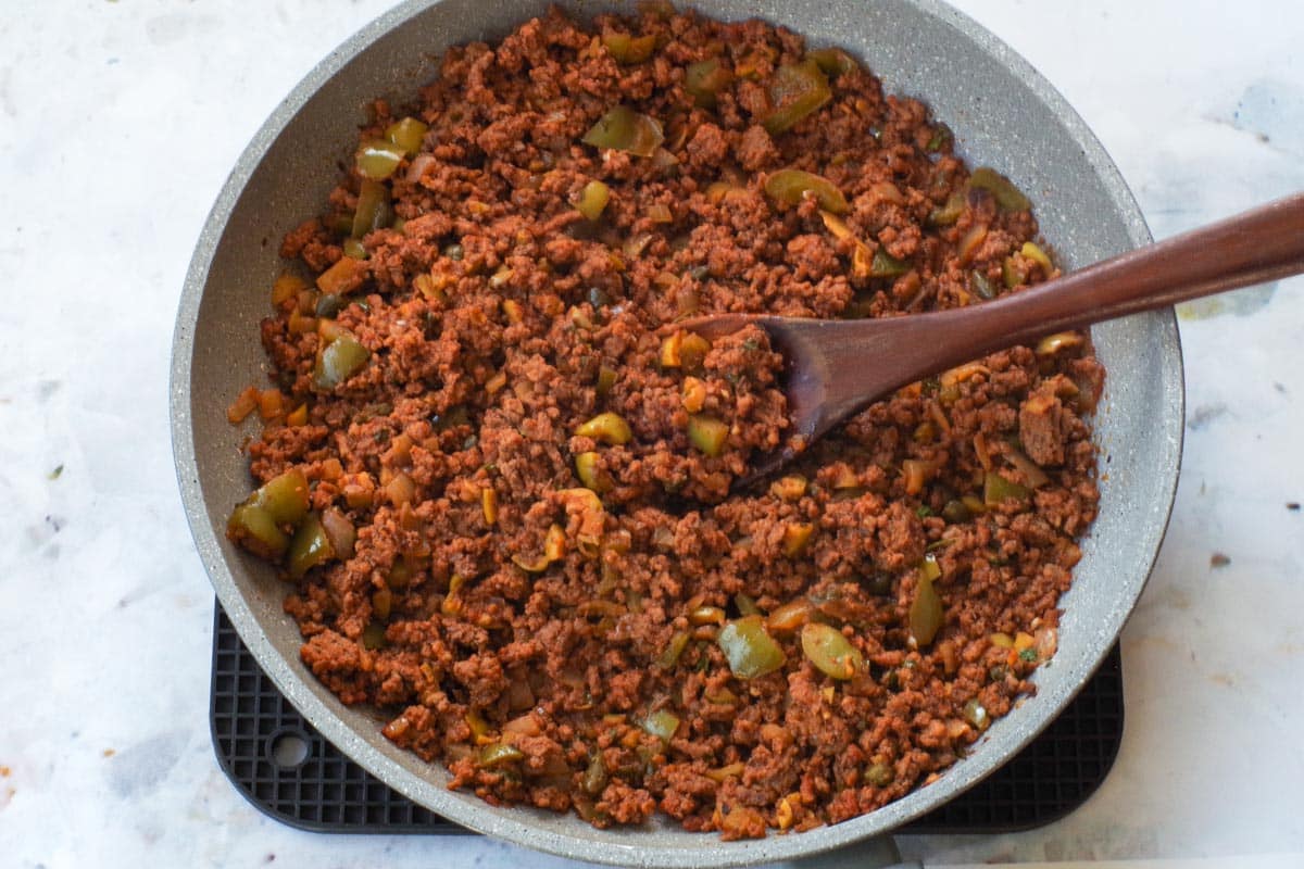 Cooked Picadillo in frying pan with wooden spoon