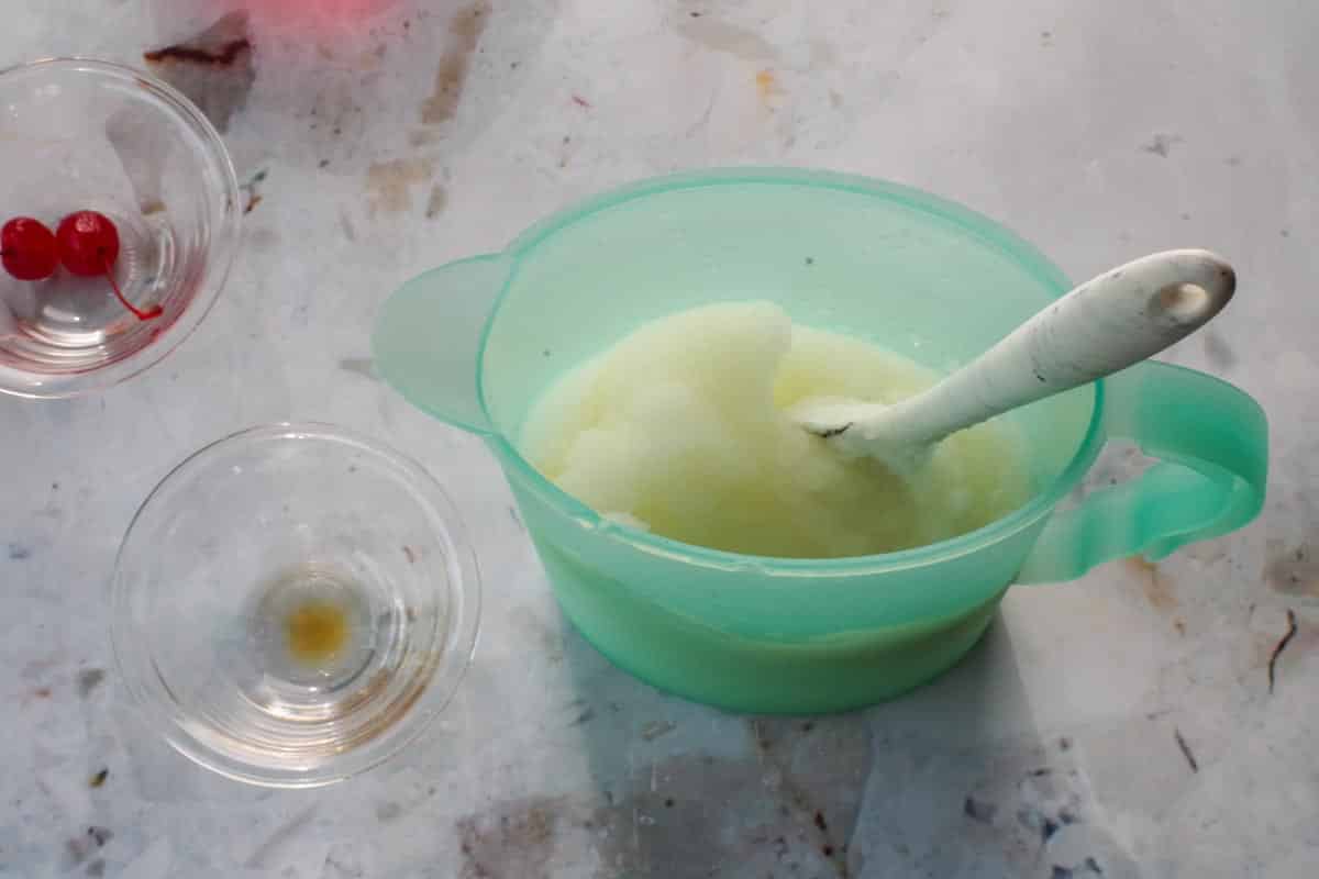 Pina Colada mixture in a blue jug, with a spoon.