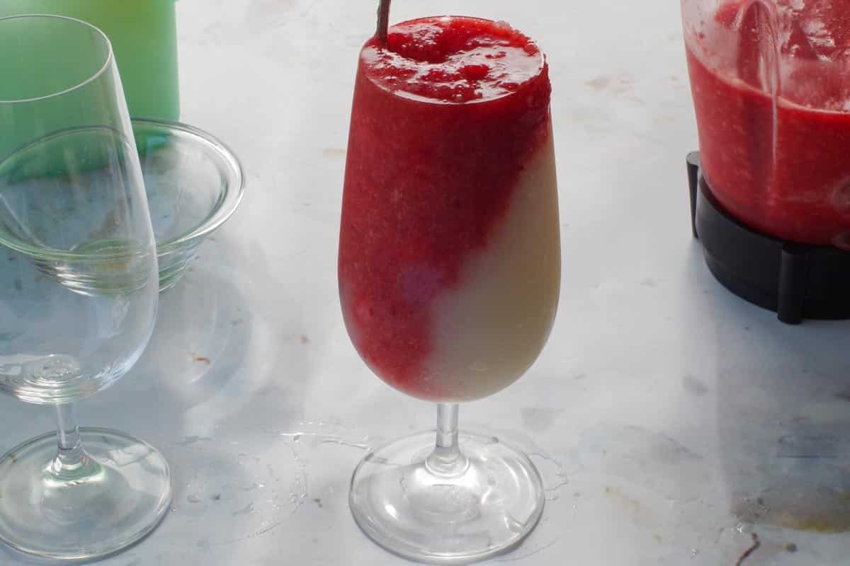 Strawberry dacquiri mixture poured into other side of glass.