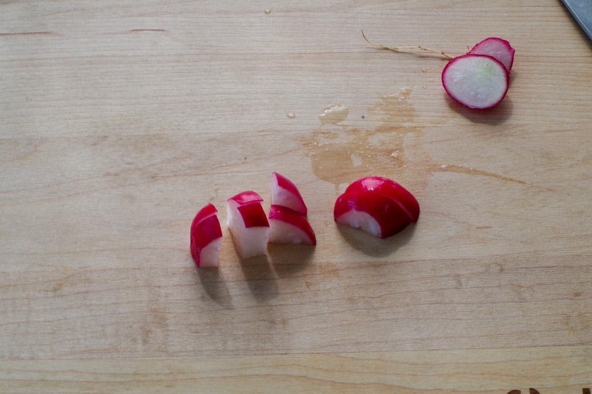 Radishes cut on cutting board.
