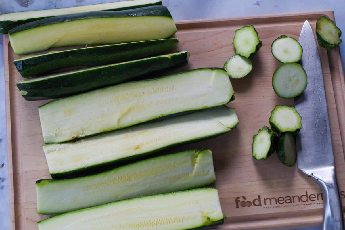 Cut zucchini on a wooden cutting board.