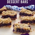 Saskatoon berry dessert bars on a cutting board with a blue and white patterned oven mitt in the background.