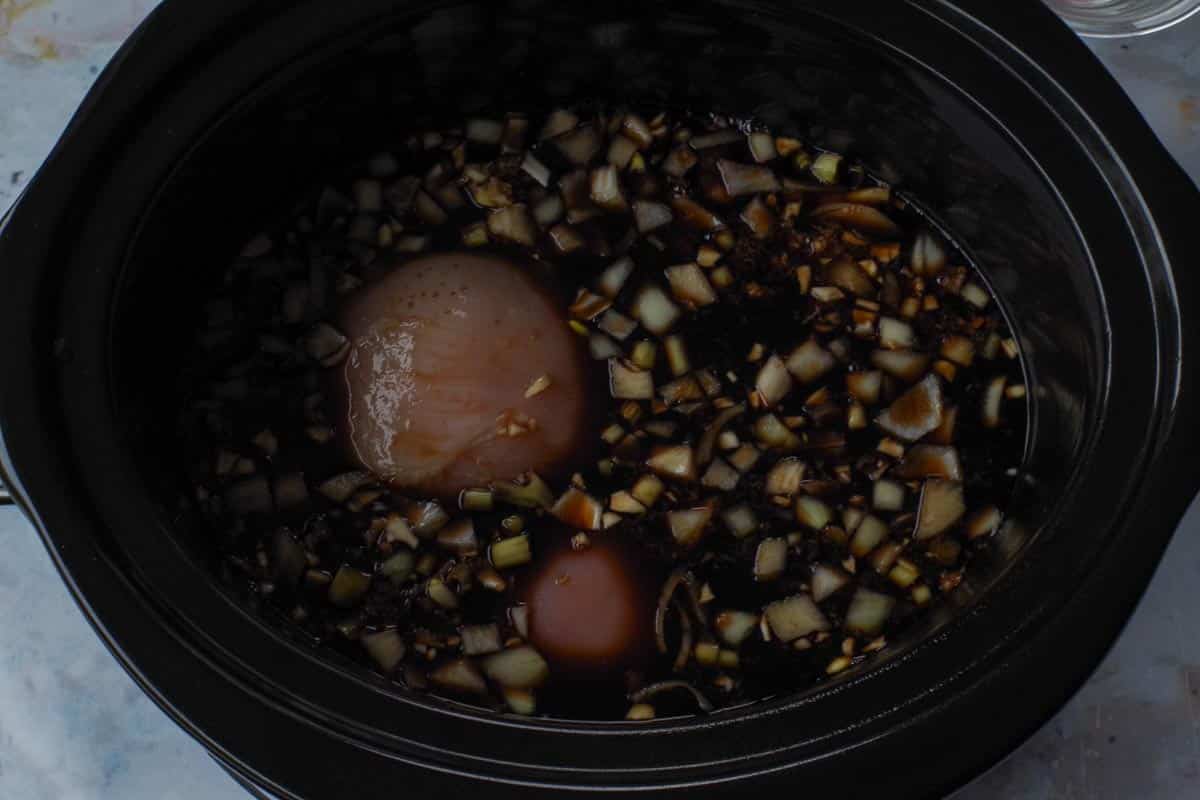 Sauce poured over chicken in slow cooker.