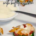 Zucchini Pizza bite with buffalo chicken on a platter with Ranch dip and more pizza bites in the background.