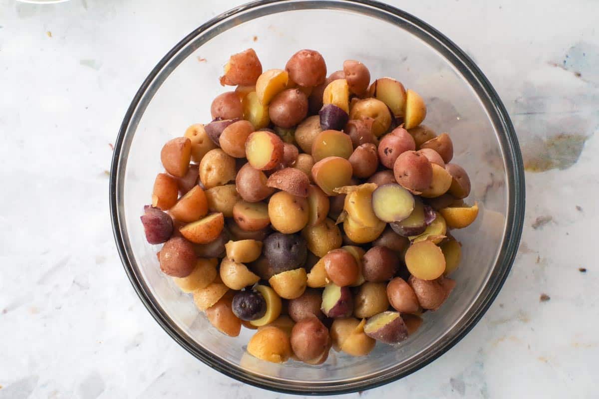Cooked and cut potatoes in glass bowl.