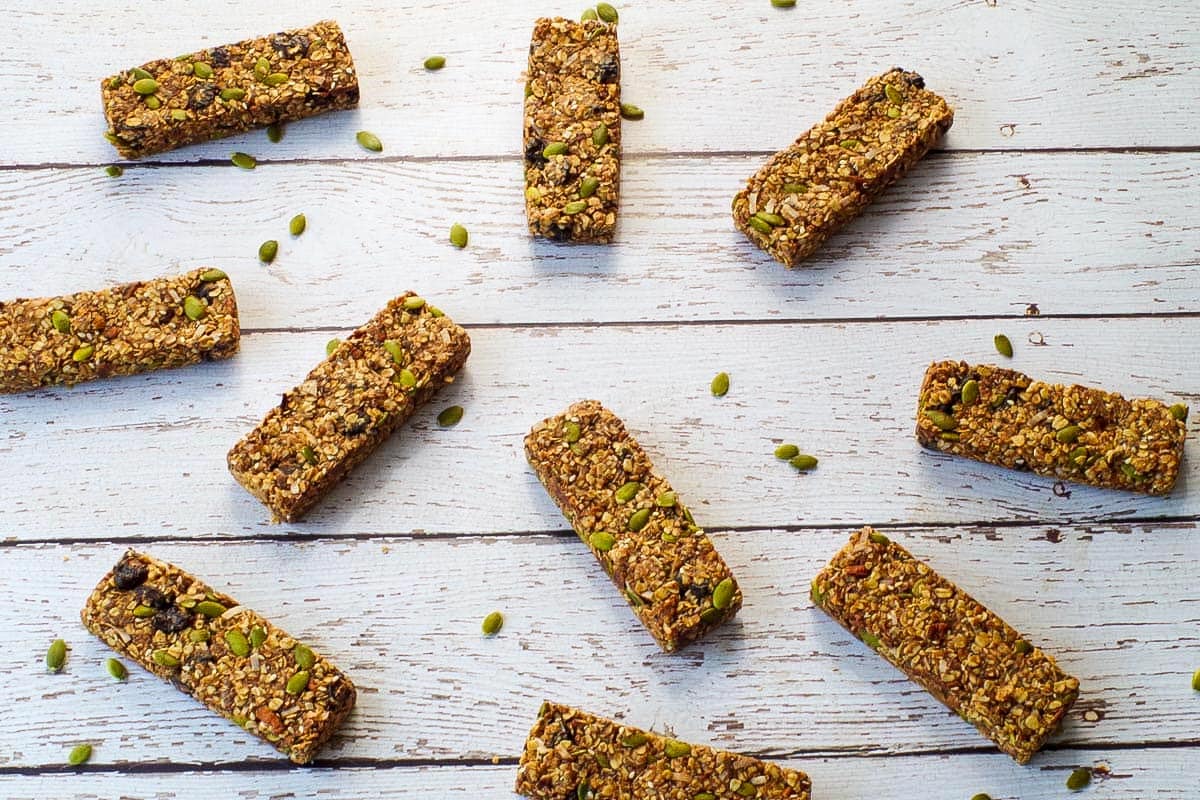 10 Almond Butter Granola Bars laying on a faux white wood surface.