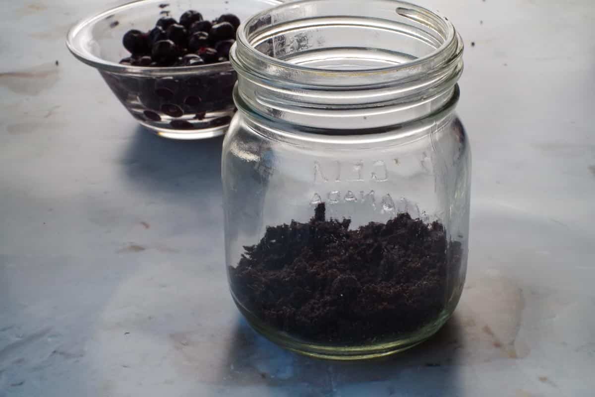 Chocolate crust mixture added to bottom of mason jar.