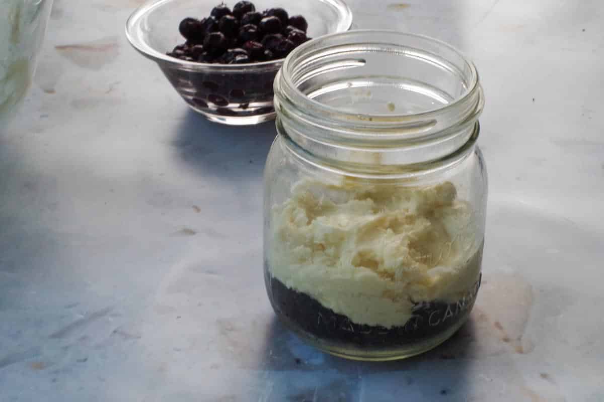 Cream cheese added to mason jar on top of chocolate crust.