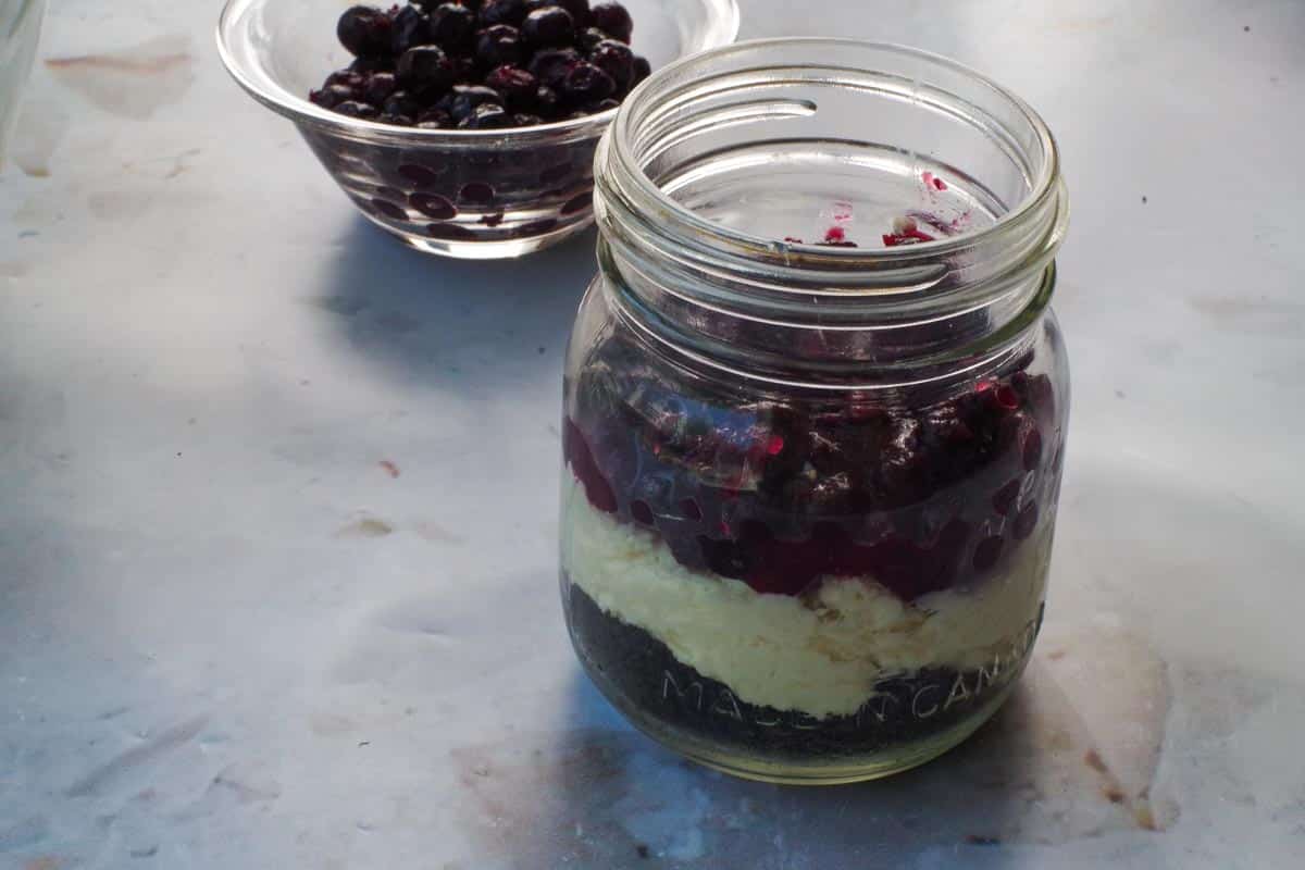 Saskatoon berry mixture added to jar on top of cream cheese mixture.