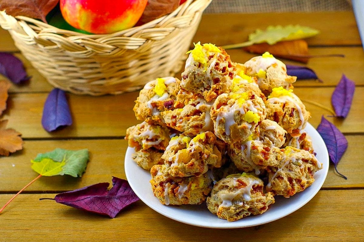 Toffee Apple Pie Cookies on a plate with a basket of apples in the background.