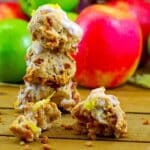 3 Apple Pie Cookies stacked with a split cookie in the front and apples in the background