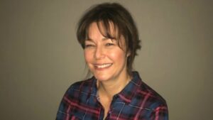 Terri Gilson, author of Food Meanderings, smiling wearing plaid shirt